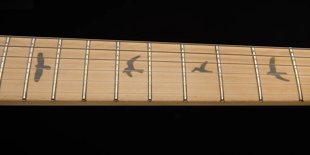 Close-up of the PRS SE Silver Sky's maple fretboard, featuring PRS bird inlays and stainless steel frets.